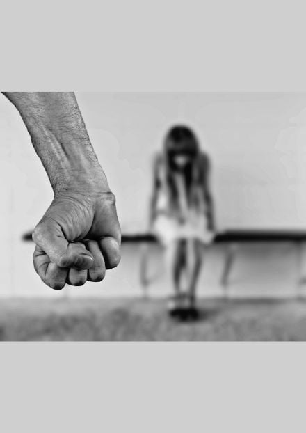 Clenched fist in foreground with a girl in the background