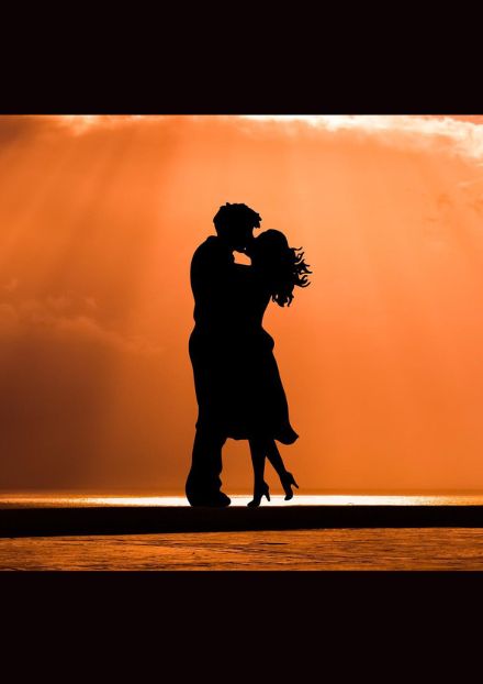 silhouette of kissing couple in sunset background